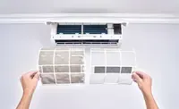 Professional technician cleaning heat pump filter during maintenance service